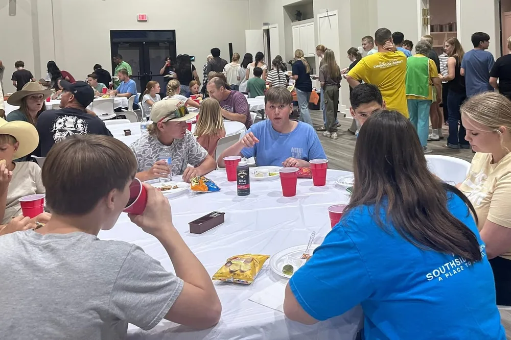Students sharing a meal at long tables during the Summer Youth Series